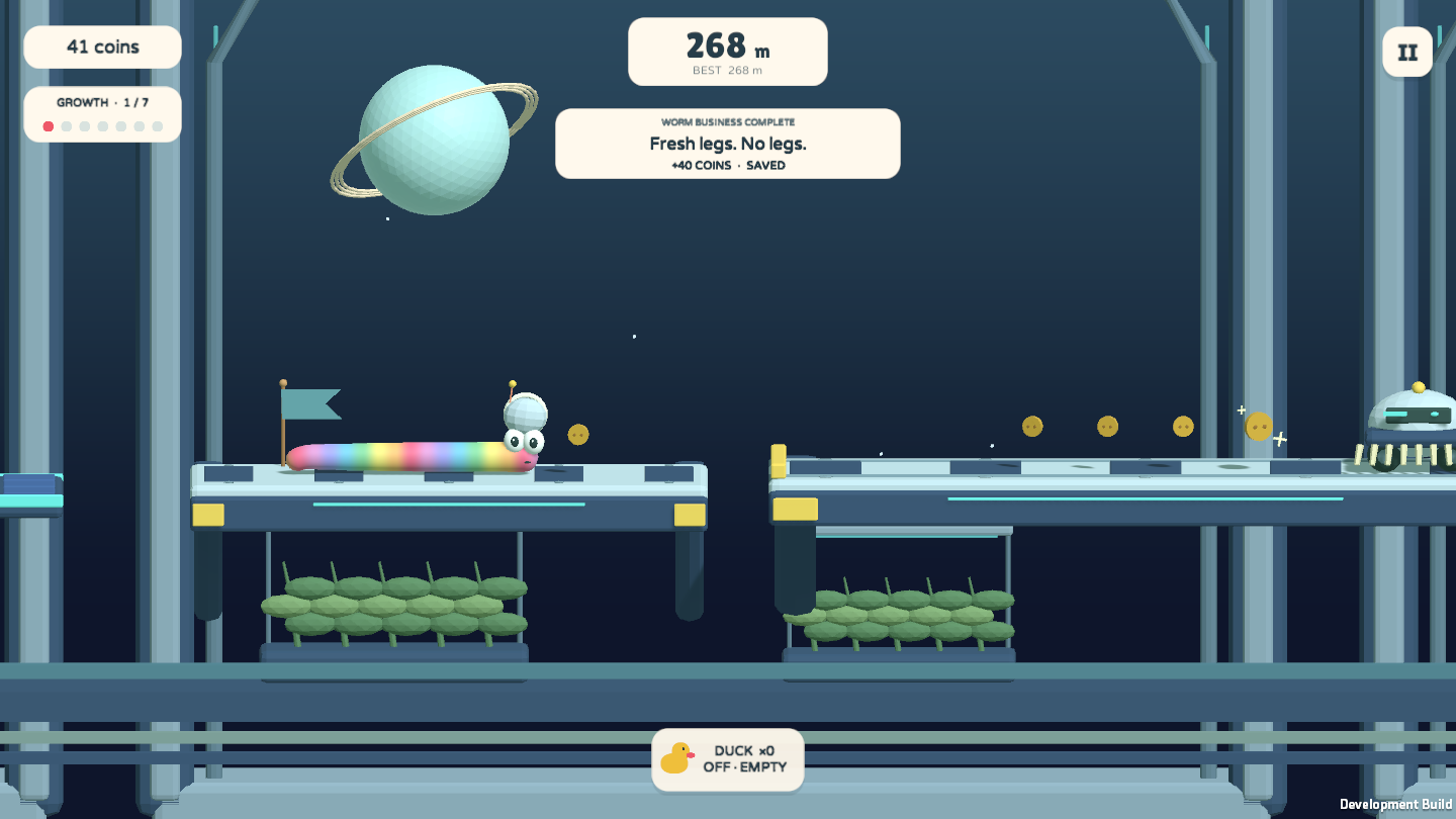 A rainbow worm wearing a space helmet stands on a platform with a ringed planet outside